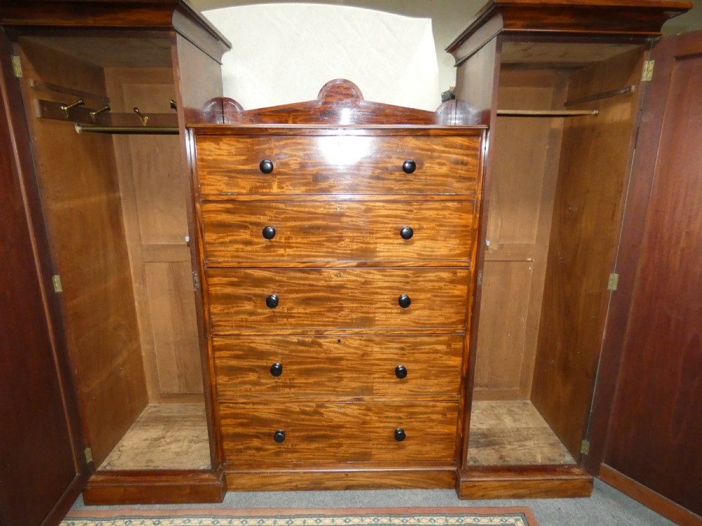 An antique Victorian mahogany combination wardrobe featuring a central stack of five drawers flanked by two tall flanking side cupboards with pediment tops. View VII