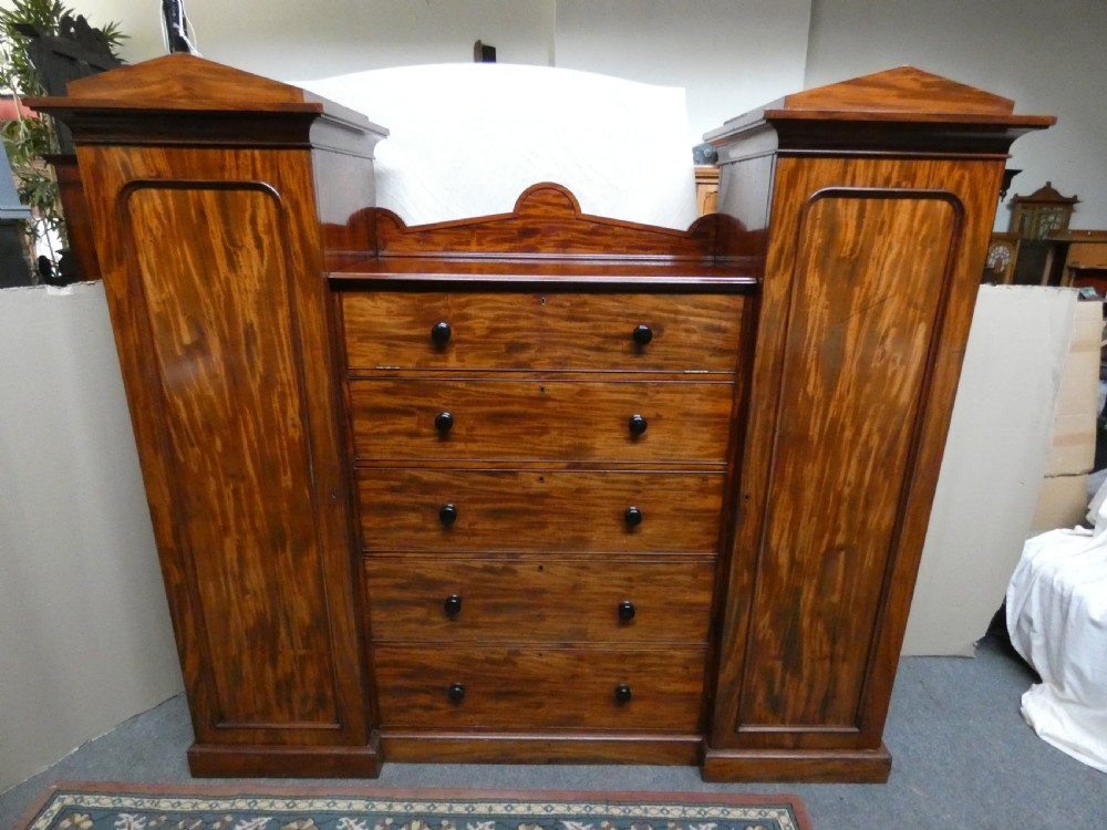 An antique Victorian mahogany combination wardrobe featuring a central stack of five drawers flanked by two tall flanking side cupboards with pediment tops. View VIII