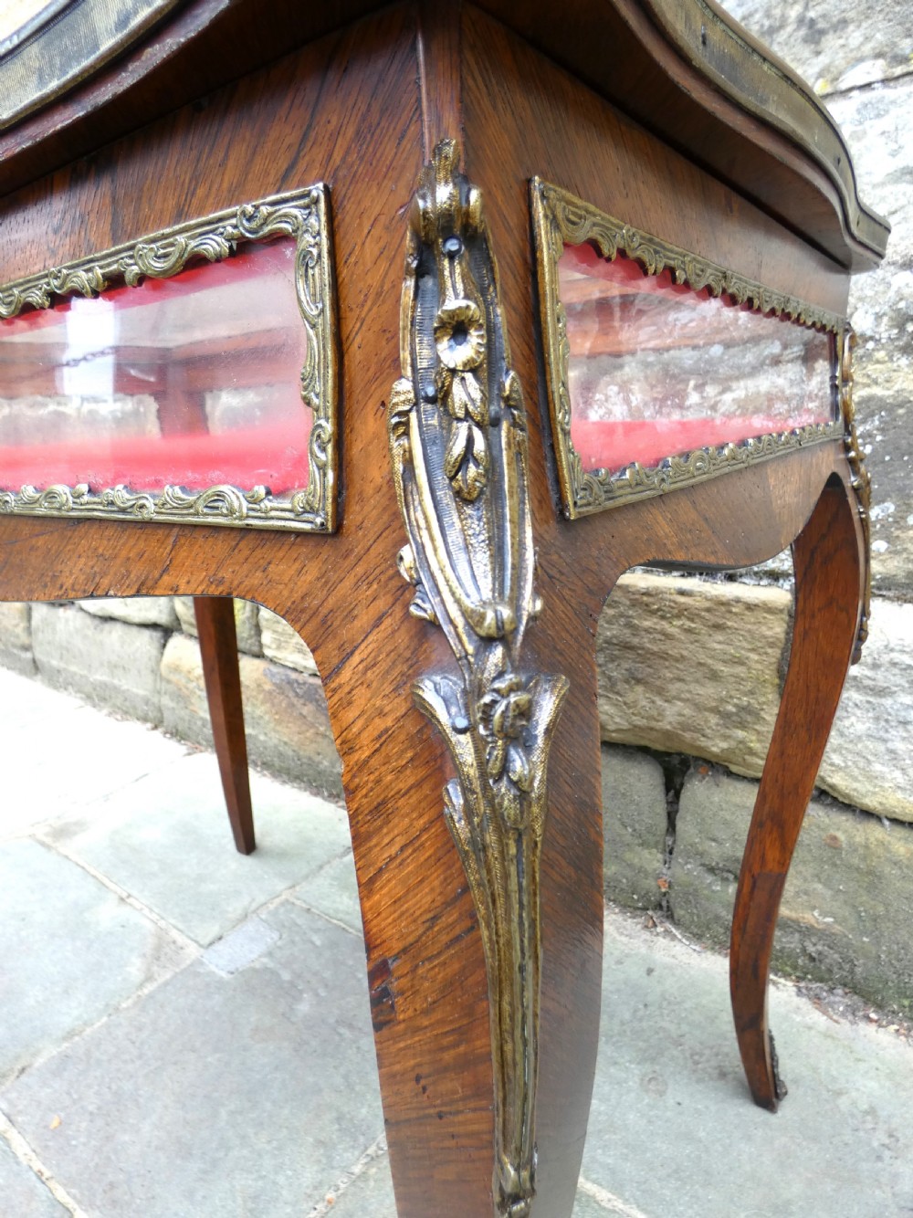 A French style rosewood bijouterie table featuring glass panels, red velvet interior lining, brass mounts, and cabriole legs. View VIII