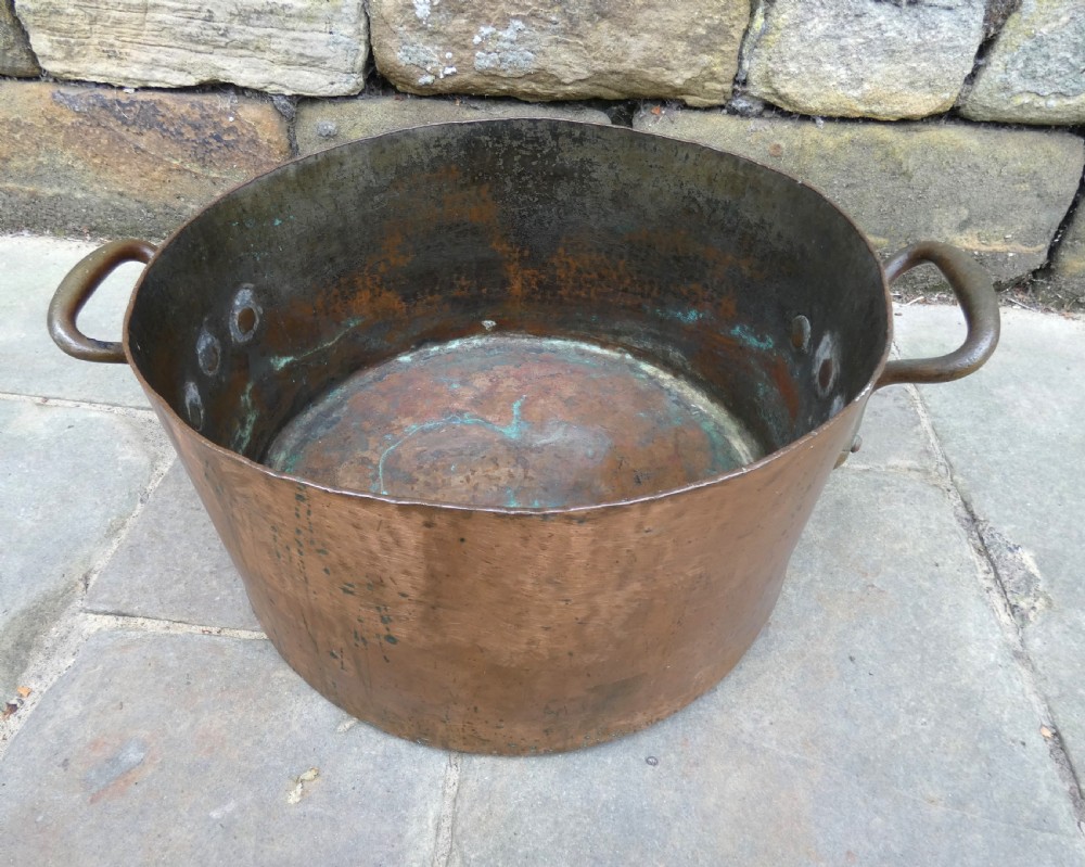 A large hand-hammered copper log bin featuring a wide cylindrical body, riveted side handles, and a natural aged patina with interior verdigris. View II
