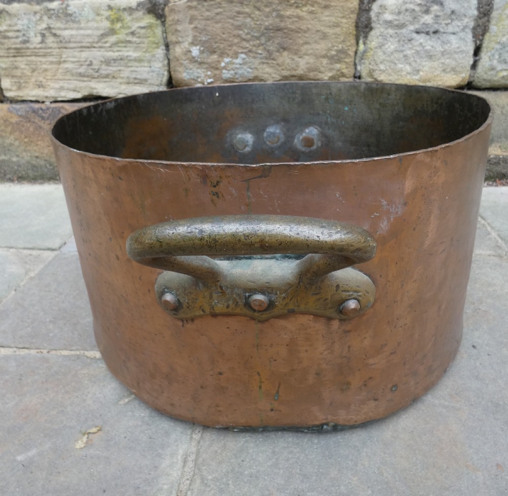 A large hand-hammered copper log bin featuring a wide cylindrical body, riveted side handles, and a natural aged patina with interior verdigris. View III