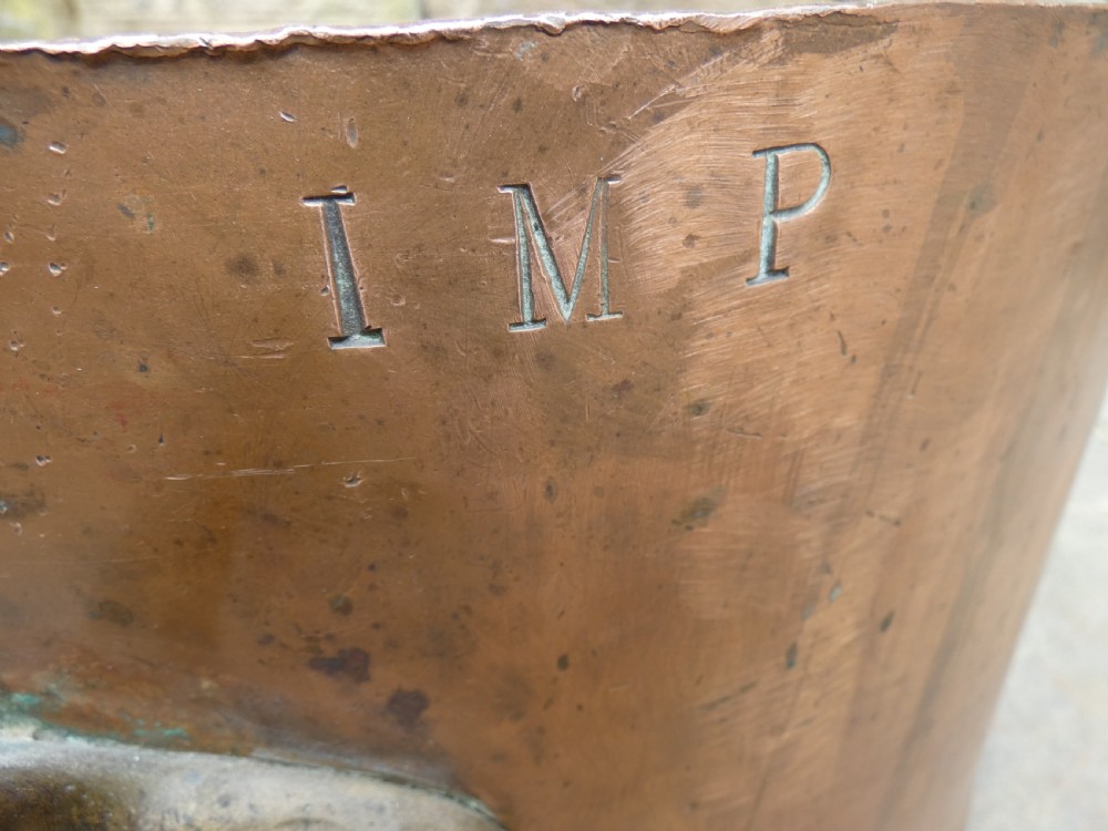 A large hand-hammered copper log bin featuring a wide cylindrical body, riveted side handles, and a natural aged patina with interior verdigris. View IV