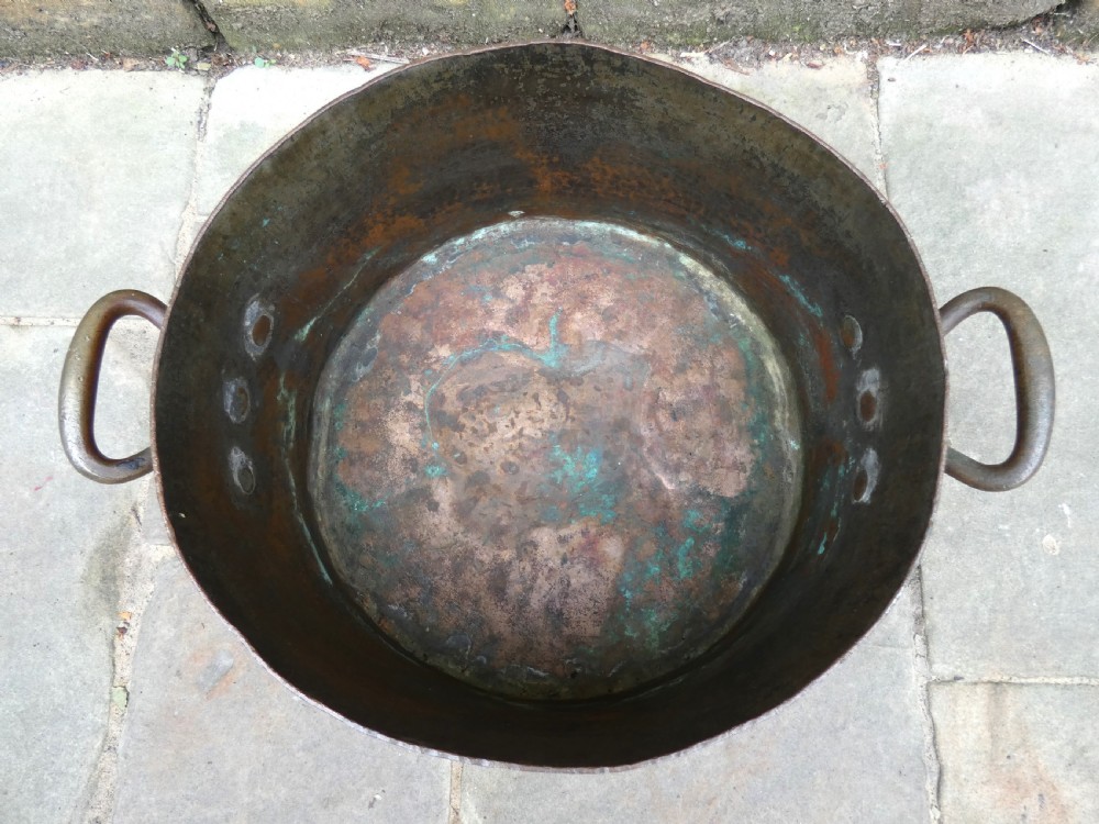 A large hand-hammered copper log bin featuring a wide cylindrical body, riveted side handles, and a natural aged patina with interior verdigris. View VI