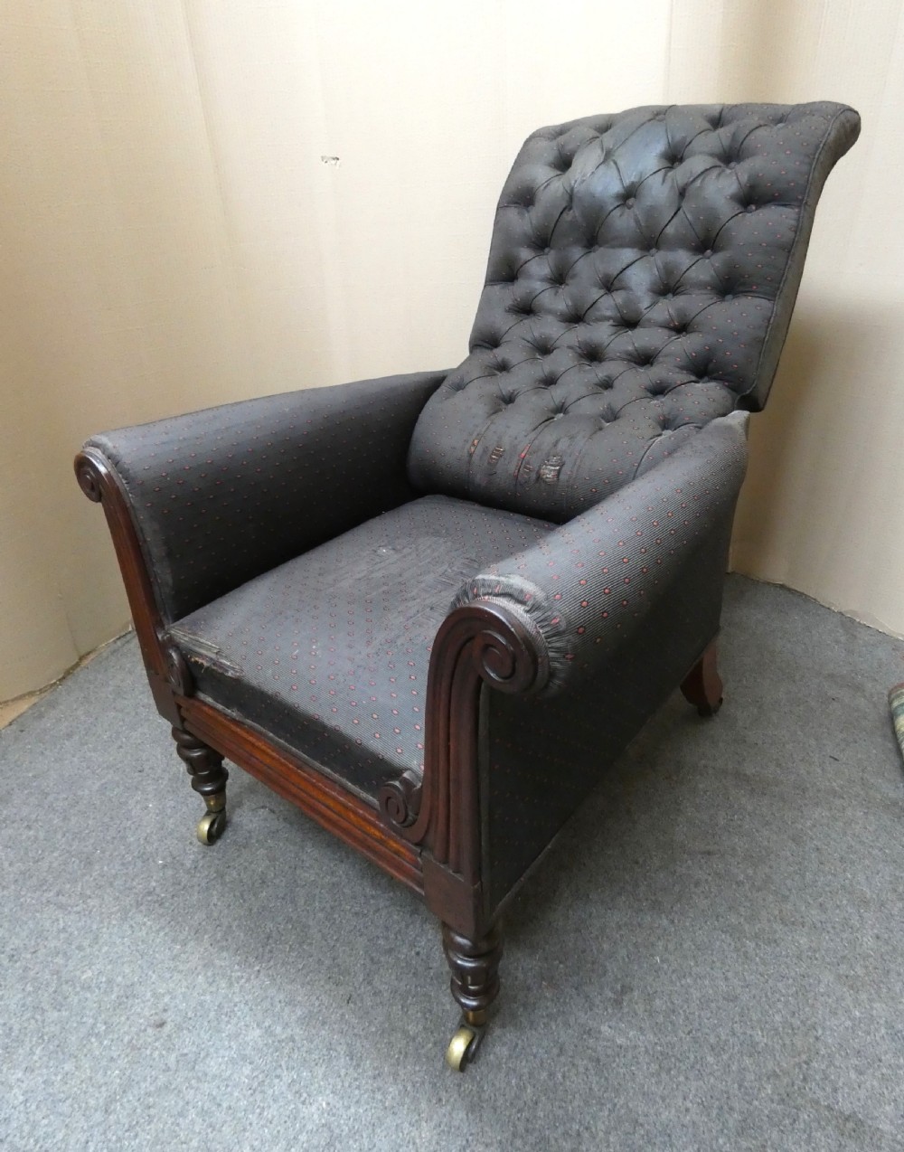 A William IV reclining library armchair featuring dark button-backed upholstery, mahogany scroll-carved arms, and turned legs with brass castors. View VII