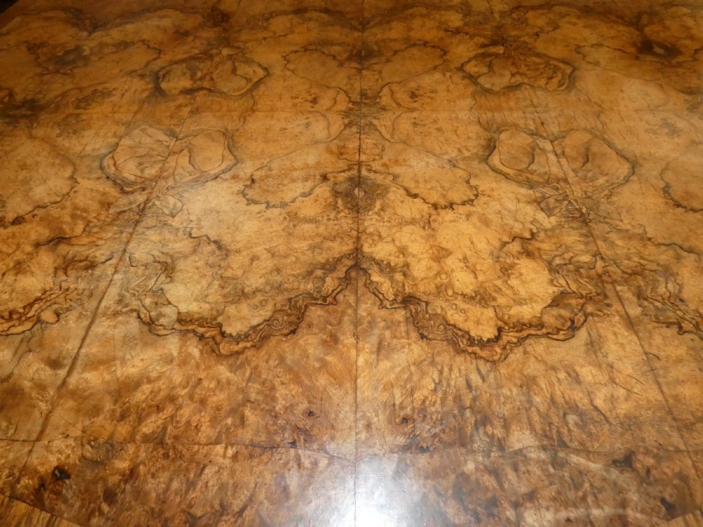 A large burr walnut partners desk featuring twin pedestals, multiple drawers with brass drop handles, and a crossbanded top surface. View XI