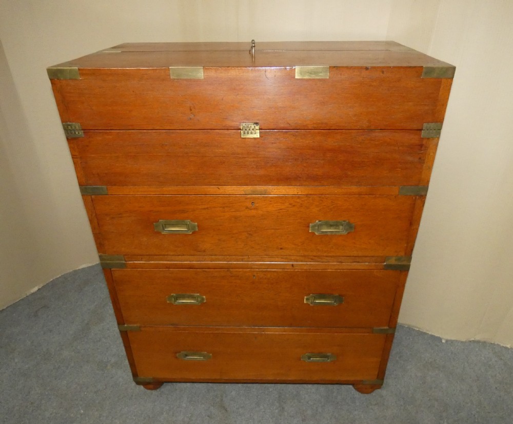 An antique teak campaign secretaire chest featuring brass corner mounts, flush drawer handles, carrying handles, and a drop-front slanted leather writing desk. View VIII