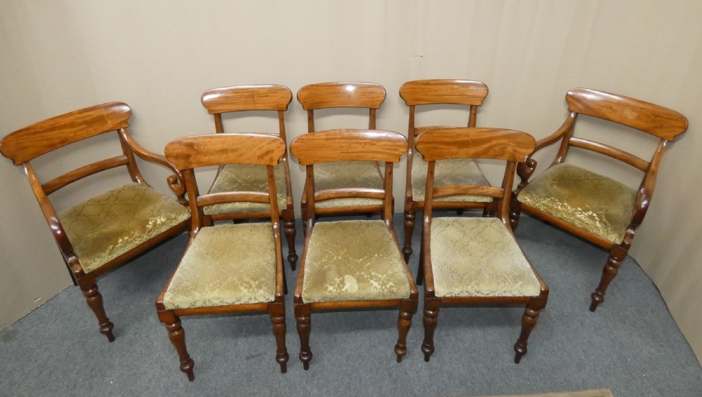 A set of eight antique mahogany dining chairs featuring curved bar backs, turned front legs, and mustard patterned fabric seats. View II