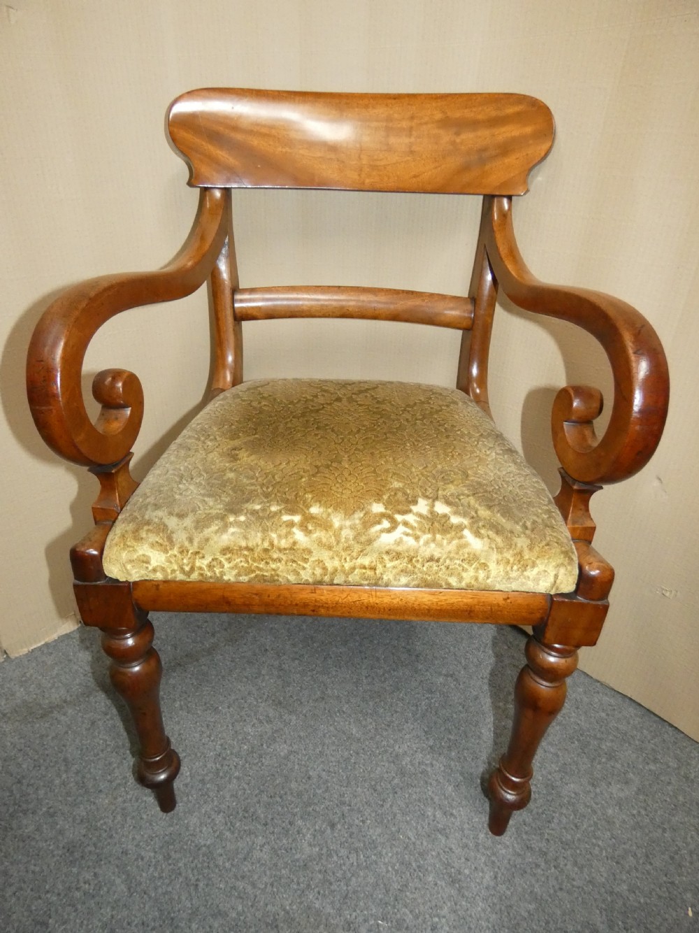 A set of eight antique mahogany dining chairs featuring curved bar backs, turned front legs, and mustard patterned fabric seats. View V