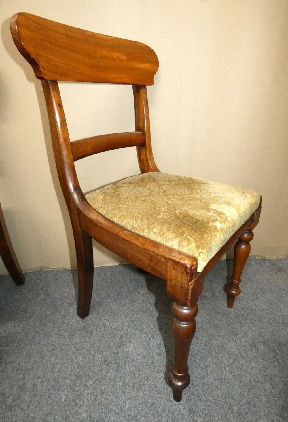 A set of eight antique mahogany dining chairs featuring curved bar backs, turned front legs, and mustard patterned fabric seats. View VI