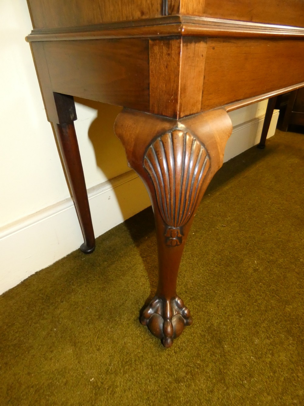 An antique mahogany bookcase featuring two astragal glazed doors, a carved fretwork frieze, and cabriole legs with claw and ball feet. View VII
