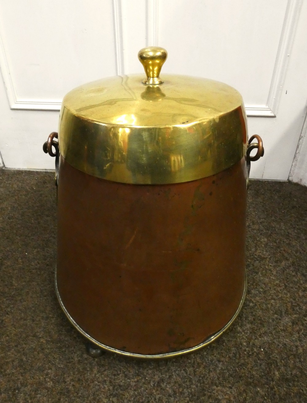 A tapered cylindrical copper coal bin featuring a polished brass collar and top finial, a copper swing handle, and decorative brass mounts. View III
