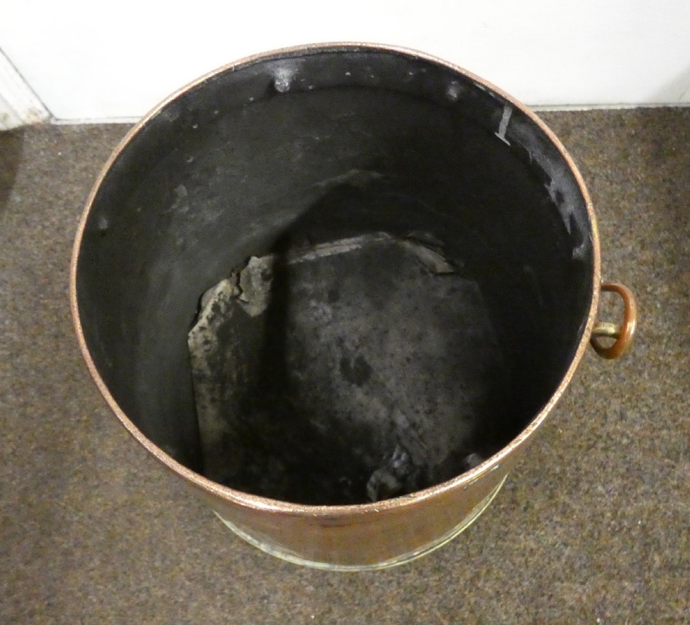 A tapered cylindrical copper coal bin featuring a polished brass collar and top finial, a copper swing handle, and decorative brass mounts. View VII