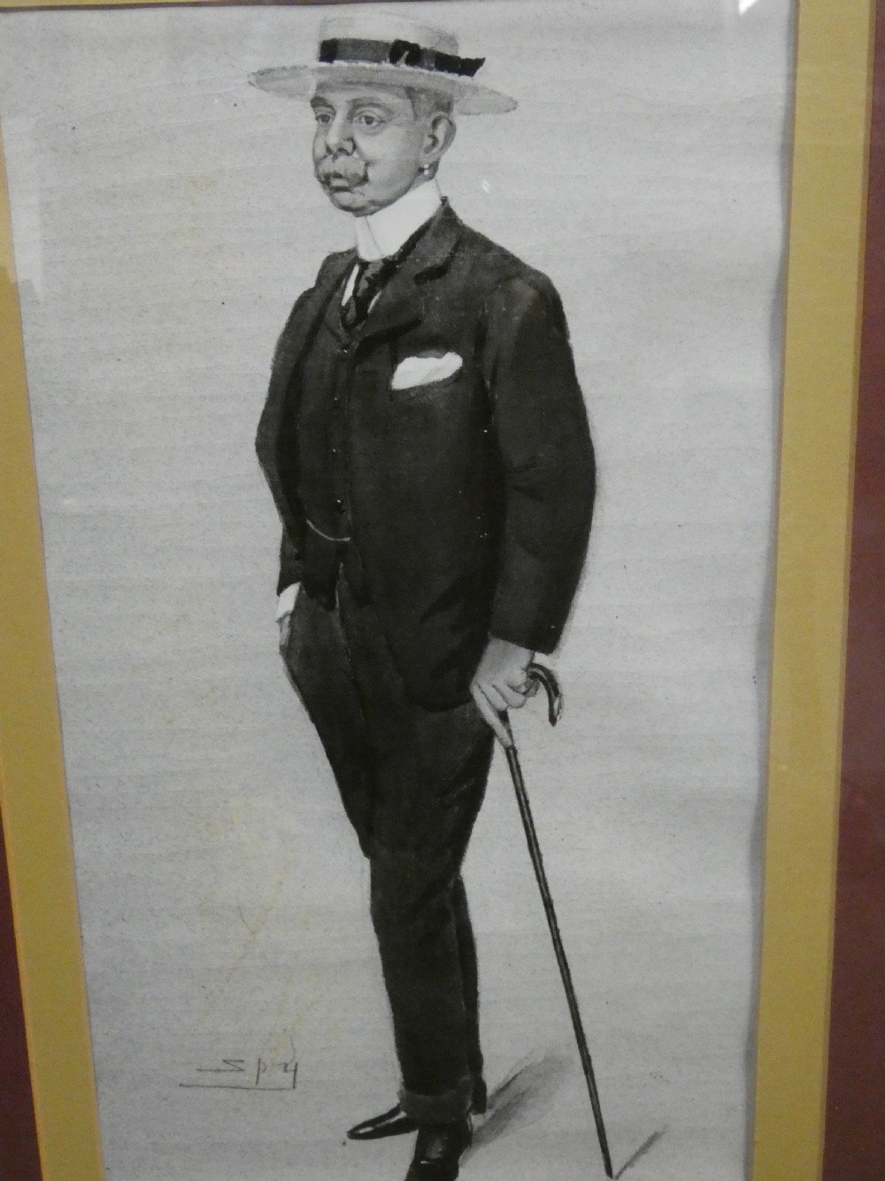 A set of six dark wooden frames, each housing two framed Victorian Vanity Fair caricature lithographs of gentlemen set against cream backgrounds with burgundy mounts. View X