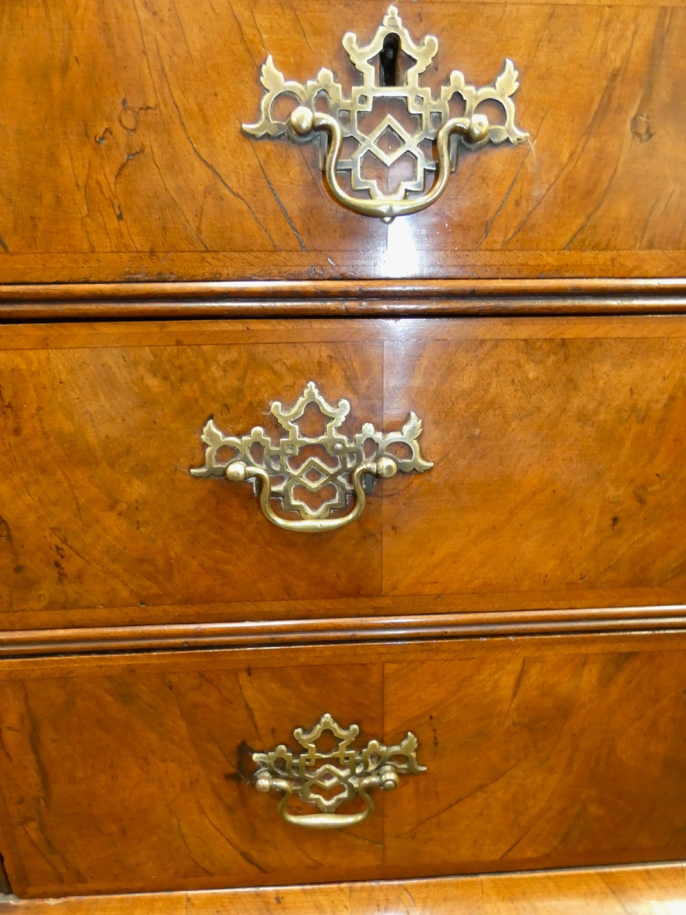 A George II period walnut slant-front bureau featuring figured veneers, brass drop handles, keyhole escutcheons, and graduating drawers on bracket feet. View VIII