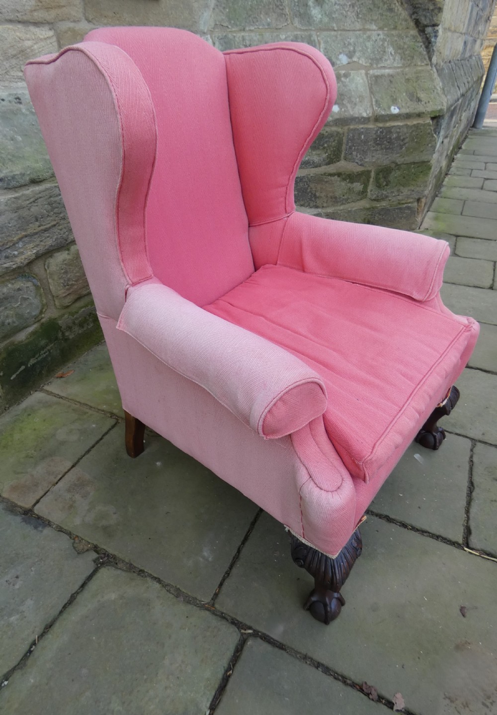 A 19th-century wingback armchair upholstered in rose pink fabric with carved mahogany cabriole front legs resting on ball-and-claw feet. View III