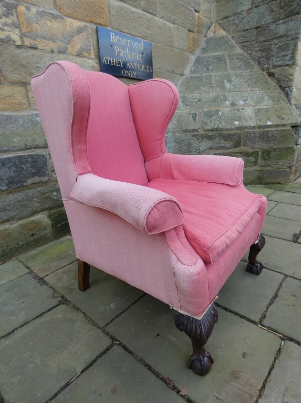 A 19th-century wingback armchair upholstered in rose pink fabric with carved mahogany cabriole front legs resting on ball-and-claw feet. View IV