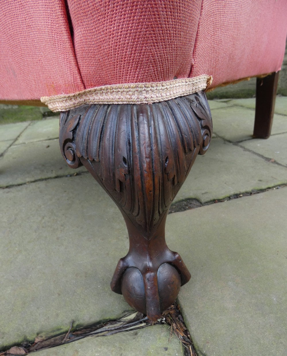 A 19th-century wingback armchair upholstered in rose pink fabric with carved mahogany cabriole front legs resting on ball-and-claw feet. View V