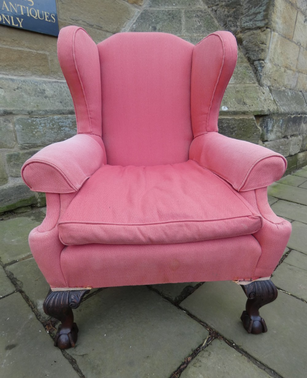 A 19th-century wingback armchair upholstered in rose pink fabric with carved mahogany cabriole front legs resting on ball-and-claw feet. View VI