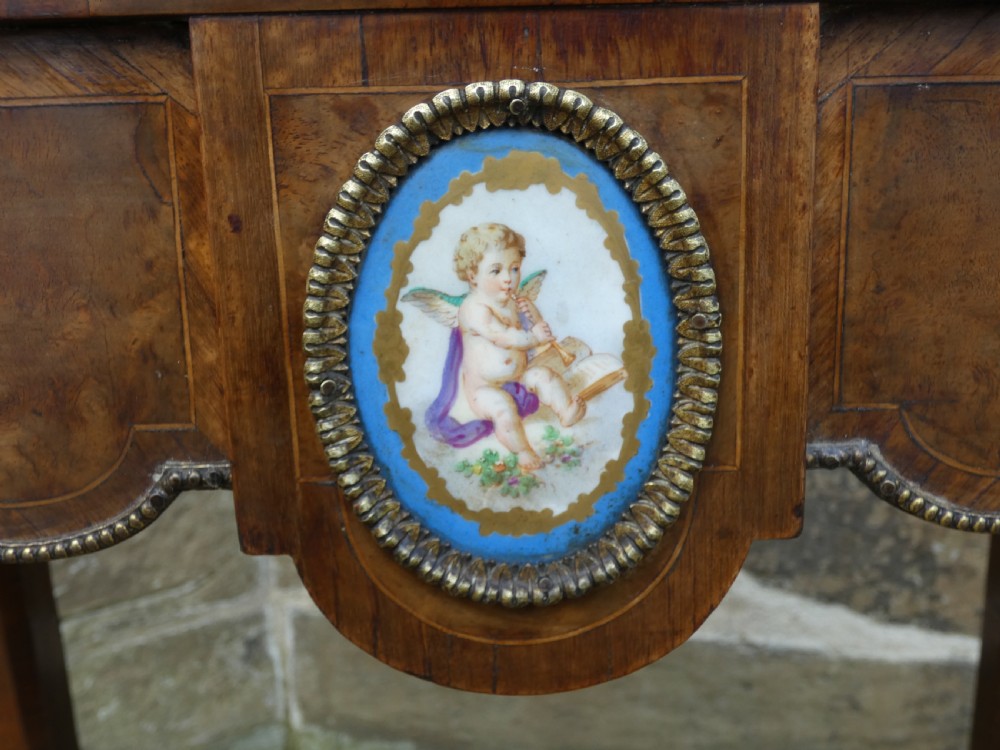 A French Louis XV style burr walnut jardiniere table with cabriole legs, ormolu mounts, a central porcelain plaque, and a brass gallery rim. View II
