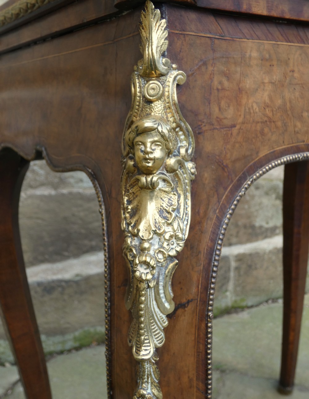 A French Louis XV style burr walnut jardiniere table with cabriole legs, ormolu mounts, a central porcelain plaque, and a brass gallery rim. View IX