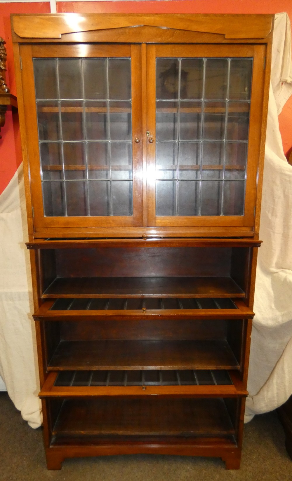 An Edwardian mahogany four-section stacking bookcase featuring leaded glass panel doors and small wooden knobs. View III