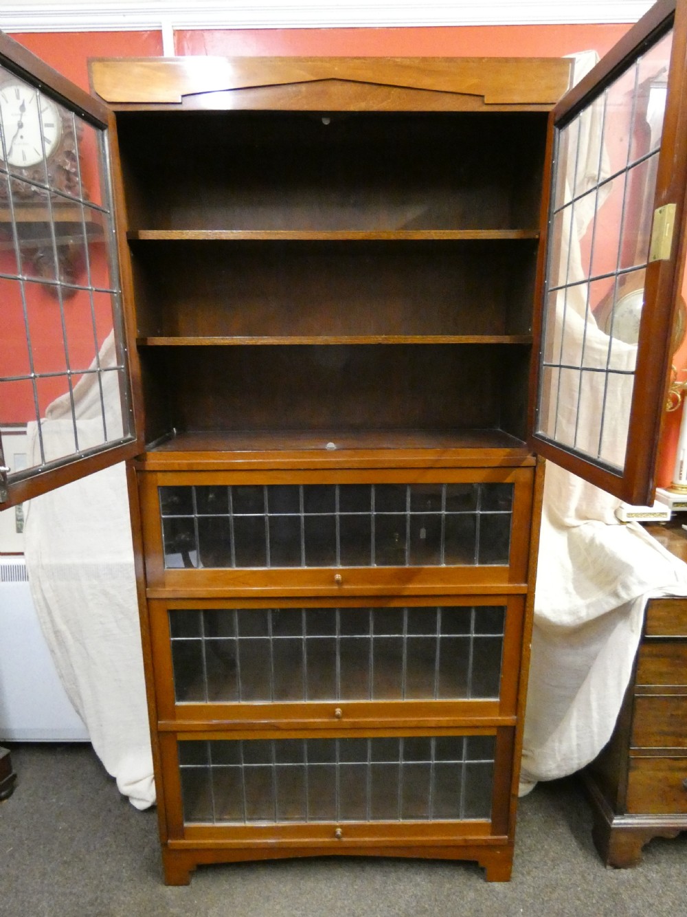 An Edwardian mahogany four-section stacking bookcase featuring leaded glass panel doors and small wooden knobs. View VI