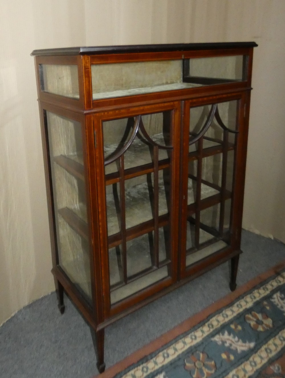 An inlaid mahogany bijouterie cabinet featuring a glass display section at the top, two glazed doors with astragal bars below, and tapered legs. View II