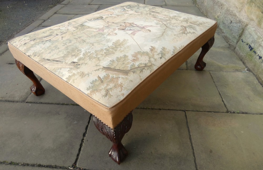 A large square upholstered centre stool featuring a tapestry top with figures in a landscape and dark carved mahogany cabriole legs with ball and claw feet. View VII