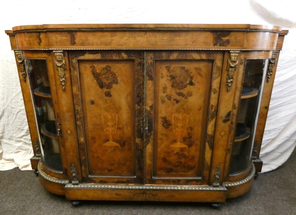 A Victorian burr walnut credenza featuring central wooden doors with marquetry urn motifs, flanked by curved glazed side compartments and gilt bronze mounts. View XI