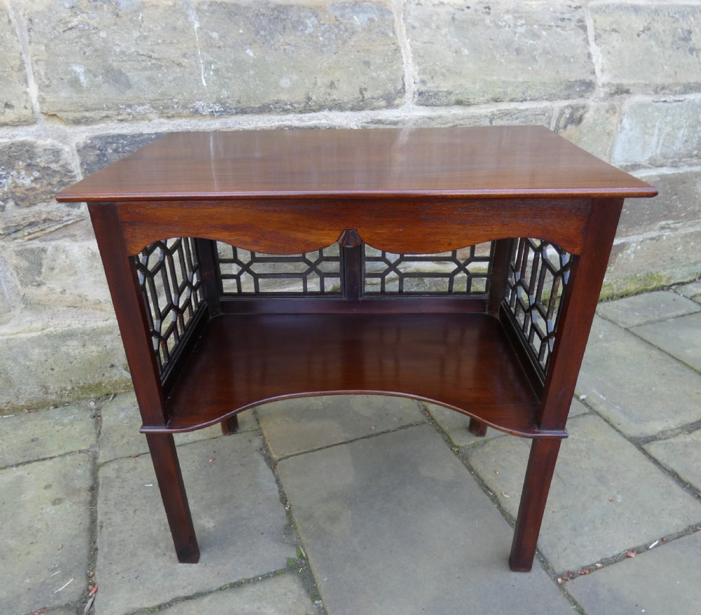 A dark mahogany side table featuring decorative geometric fretwork panels and a curved lower shelf. View II