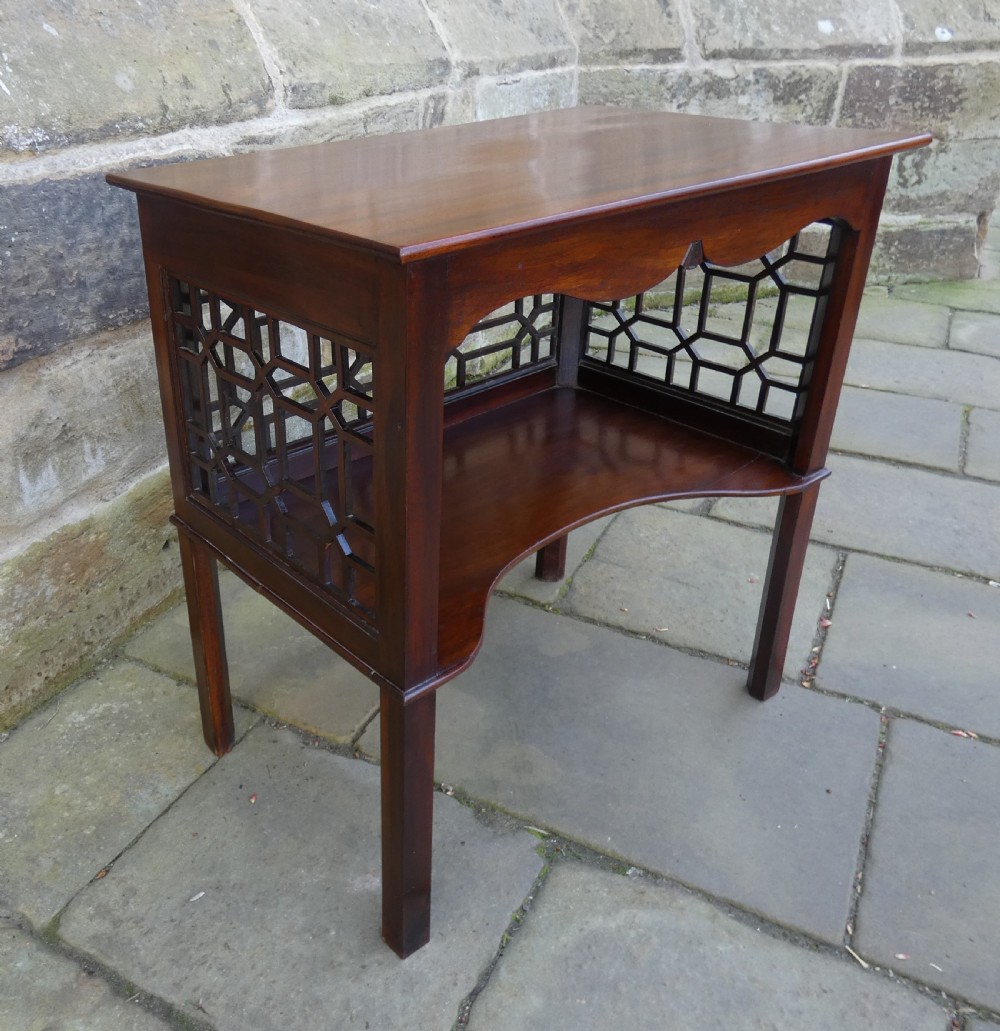 A dark mahogany side table featuring decorative geometric fretwork panels and a curved lower shelf. View III