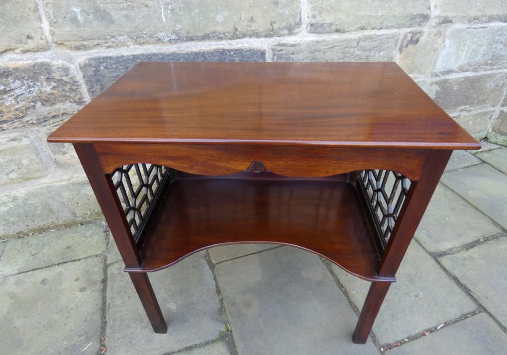 A dark mahogany side table featuring decorative geometric fretwork panels and a curved lower shelf. View V