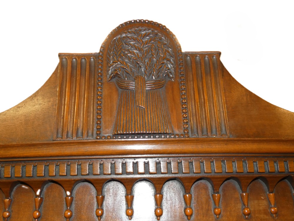 An antique bow-front mahogany chest on chest featuring graduated drawers, brass oval drop handles, and a carved pediment crown. View II