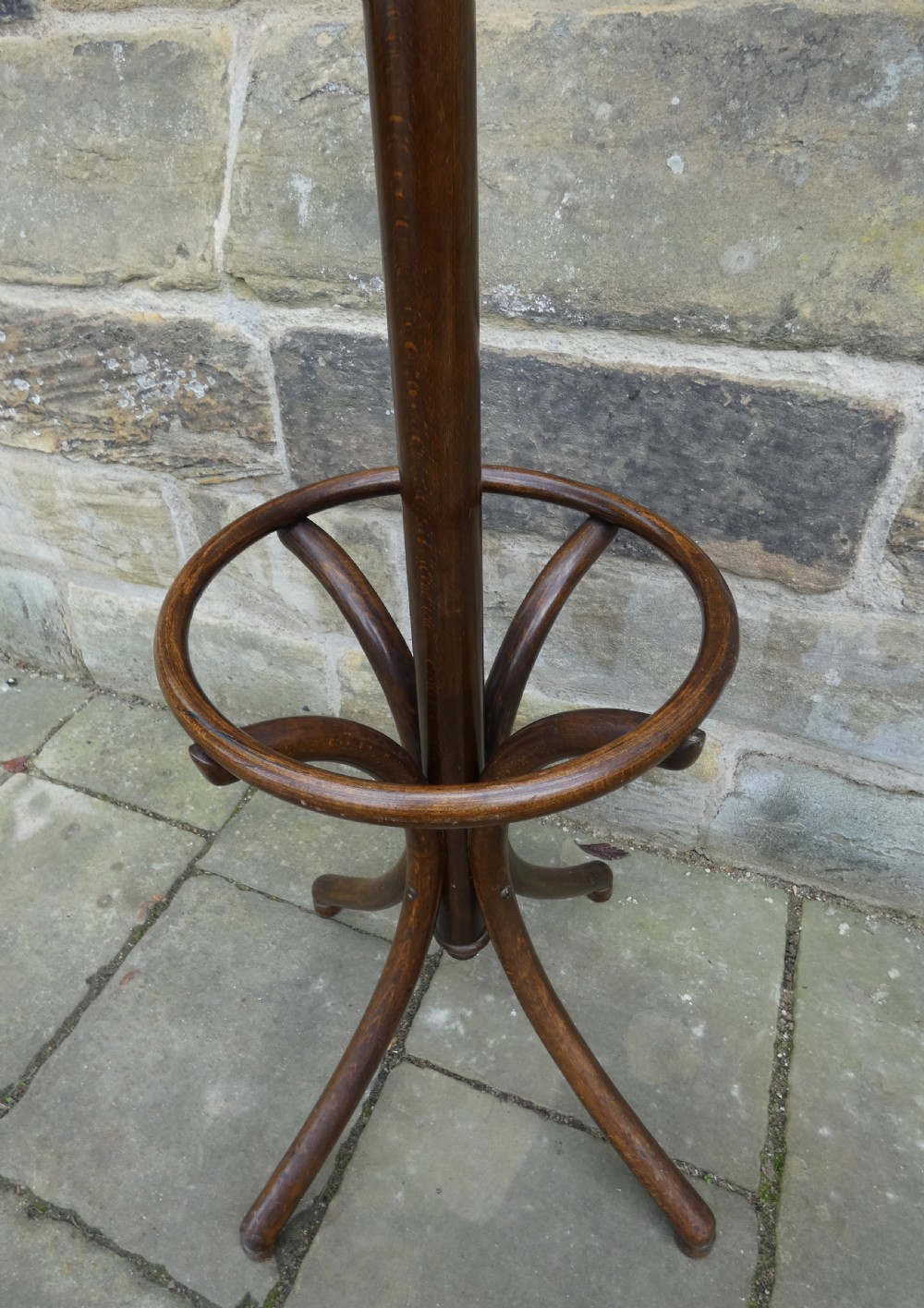 A dark brown steam-bent beechwood coat stand featuring a revolving top with double scrolled hooks, an umbrella ring, and a four-legged splayed base. View V