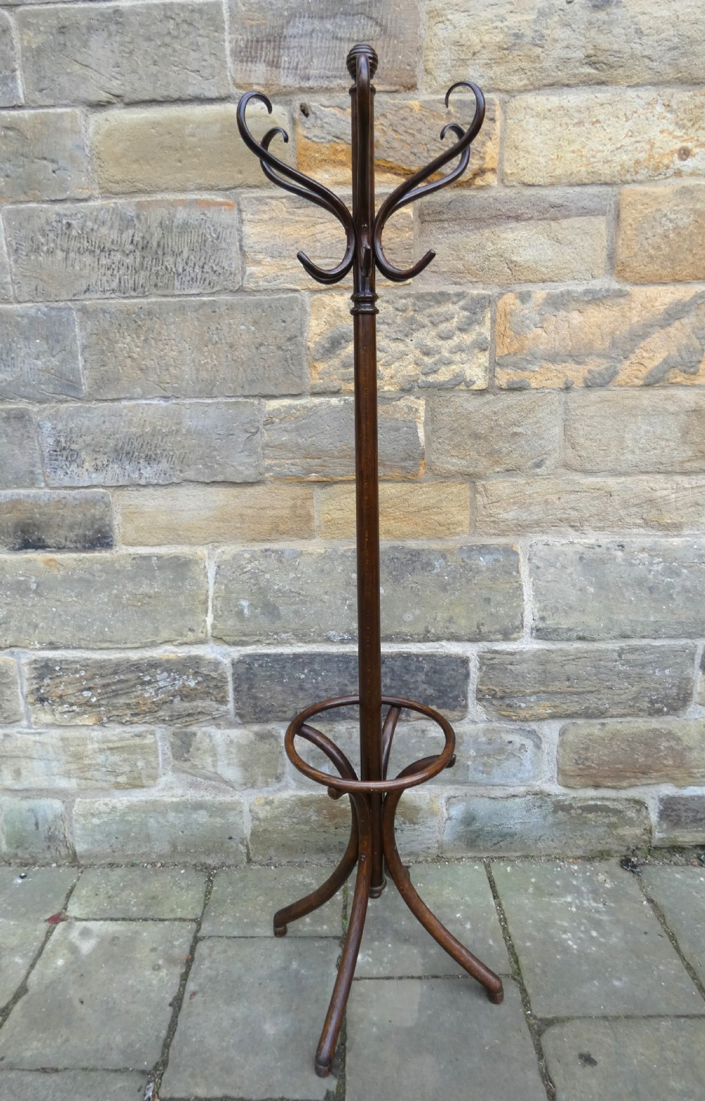 A dark brown steam-bent beechwood coat stand featuring a revolving top with double scrolled hooks, an umbrella ring, and a four-legged splayed base. View VII