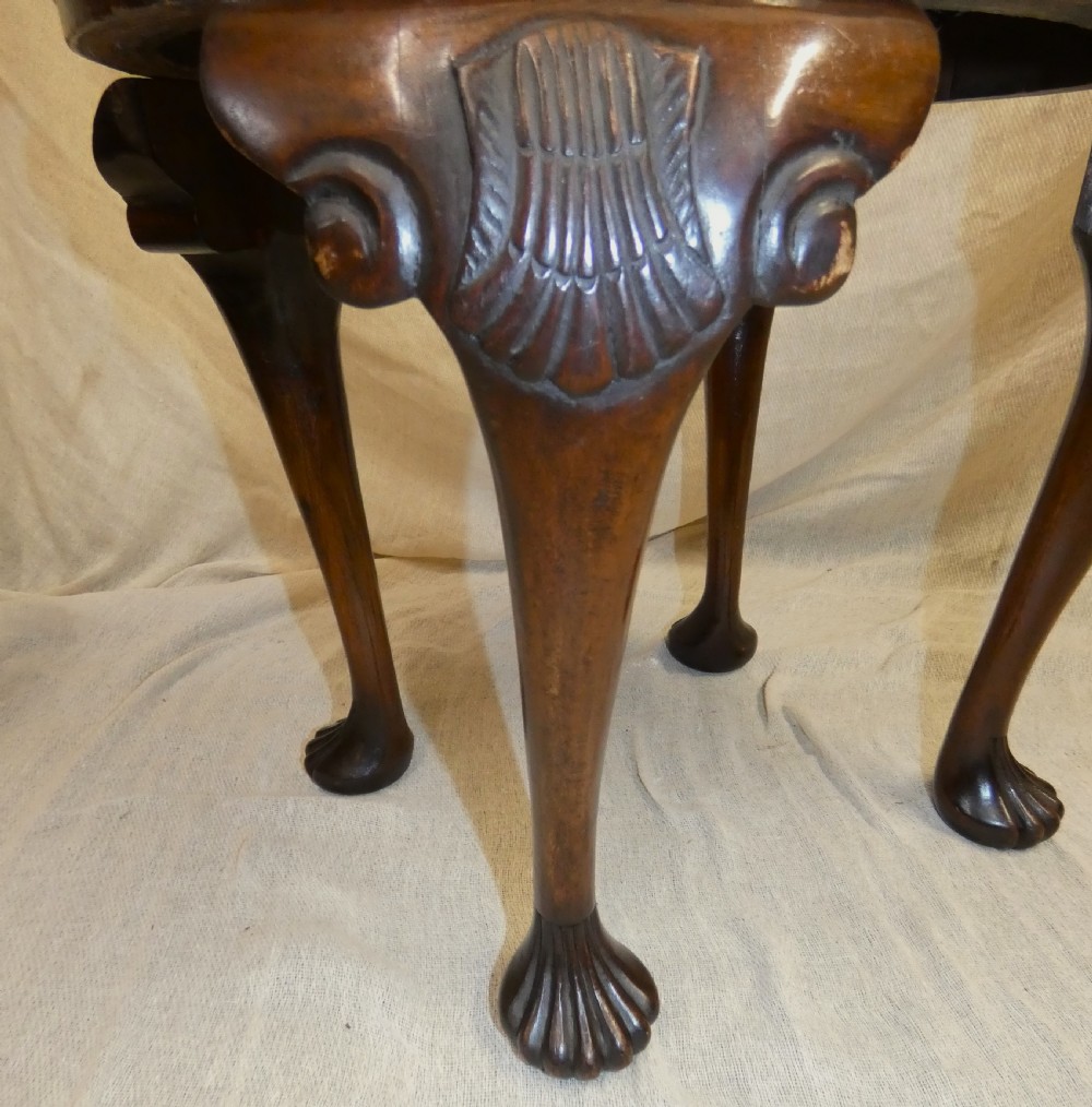 An oval upholstered antique dressing stool featuring cream damask fabric and dark mahogany cabriole legs with carved ball and claw feet. View II