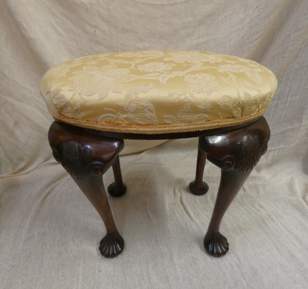 An oval upholstered antique dressing stool featuring cream damask fabric and dark mahogany cabriole legs with carved ball and claw feet. View III
