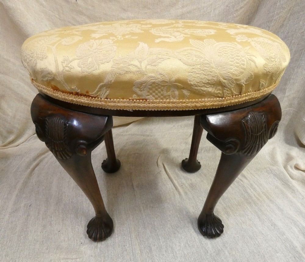 An oval upholstered antique dressing stool featuring cream damask fabric and dark mahogany cabriole legs with carved ball and claw feet. View VI