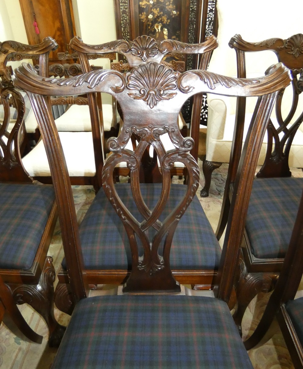 A set of eight dark mahogany Chippendale style dining chairs featuring carved pierced splats, cabriole legs with ball and claw feet, and blue tartan upholstered seats. View II