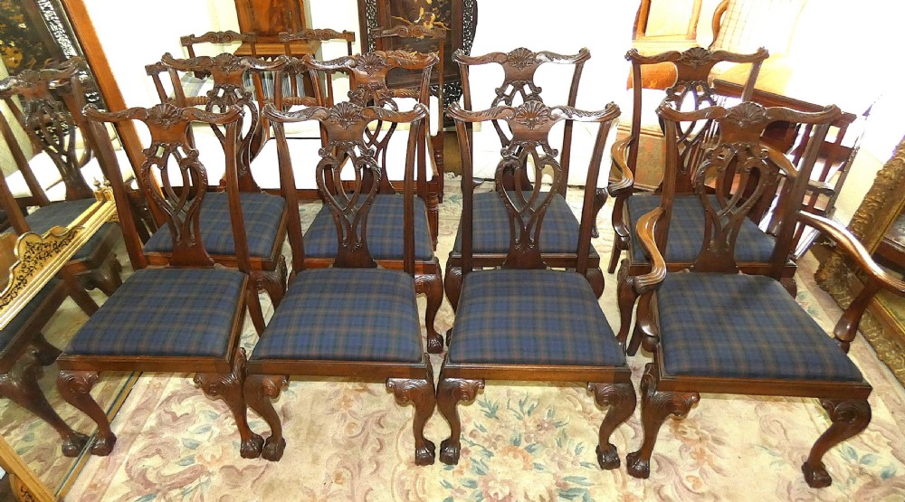 A set of eight dark mahogany Chippendale style dining chairs featuring carved pierced splats, cabriole legs with ball and claw feet, and blue tartan upholstered seats. View V