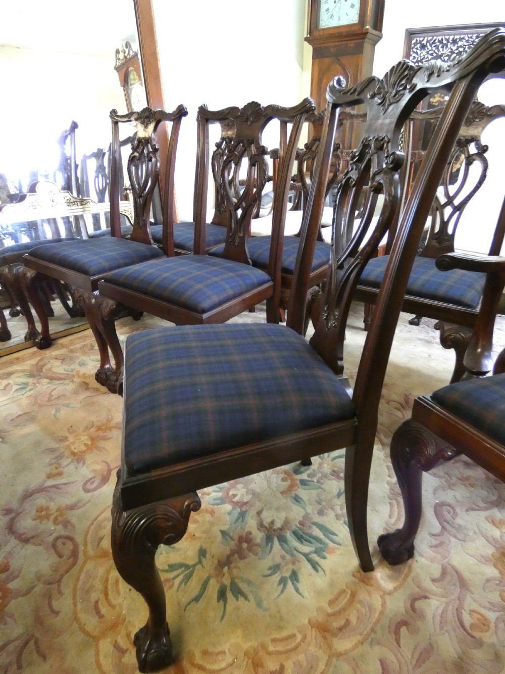 A set of eight dark mahogany Chippendale style dining chairs featuring carved pierced splats, cabriole legs with ball and claw feet, and blue tartan upholstered seats. View VII