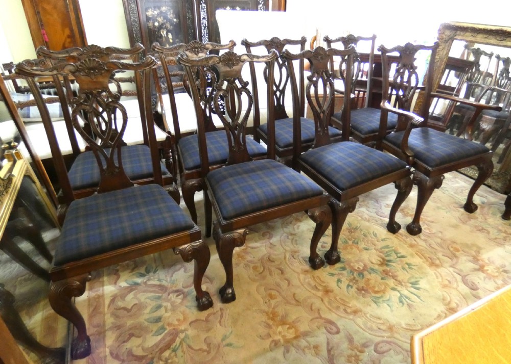A set of eight dark mahogany Chippendale style dining chairs featuring carved pierced splats, cabriole legs with ball and claw feet, and blue tartan upholstered seats. View IX