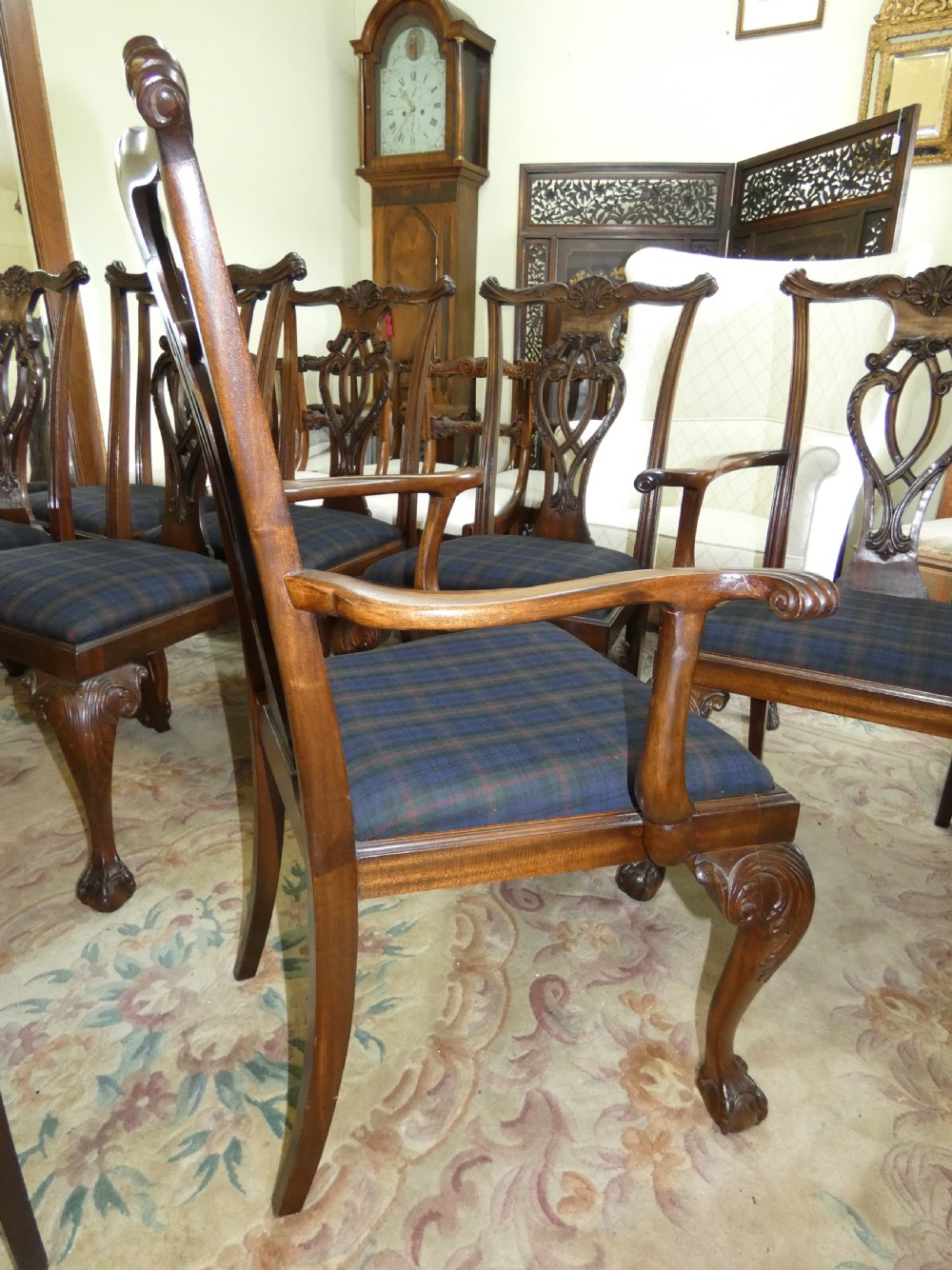 A set of eight dark mahogany Chippendale style dining chairs featuring carved pierced splats, cabriole legs with ball and claw feet, and blue tartan upholstered seats. View XI