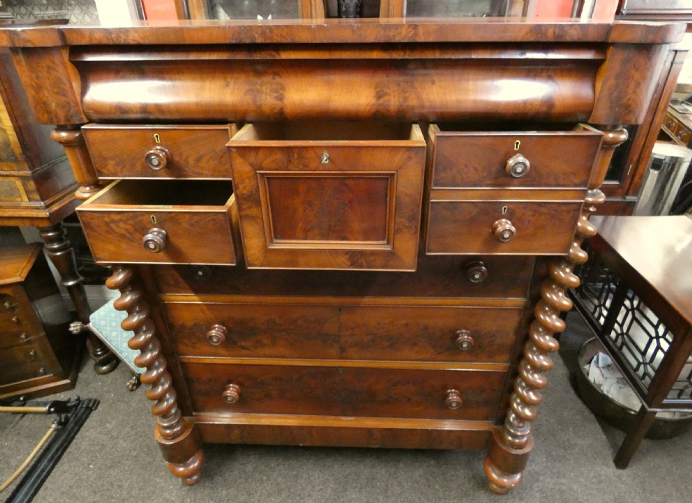A tall Victorian flame mahogany Scotch chest of drawers featuring spiral barley twist side columns, a central square drawer flanked by smaller drawers, and three long graduated drawers below. View III