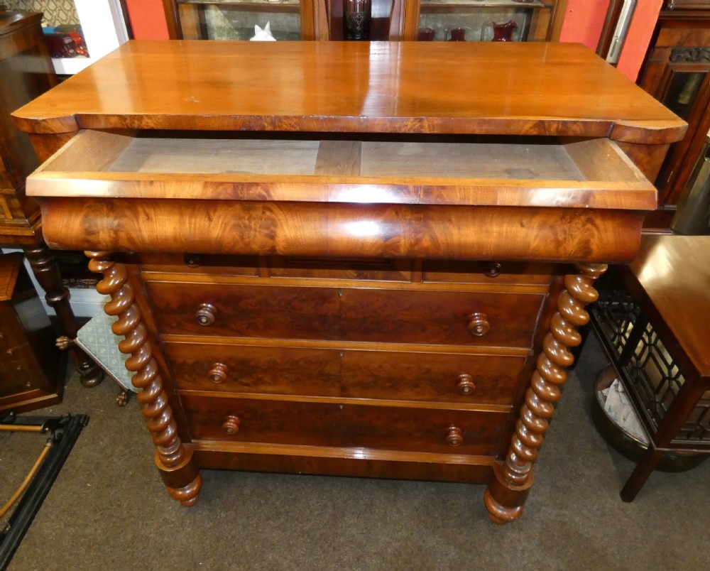 A tall Victorian flame mahogany Scotch chest of drawers featuring spiral barley twist side columns, a central square drawer flanked by smaller drawers, and three long graduated drawers below. View VII