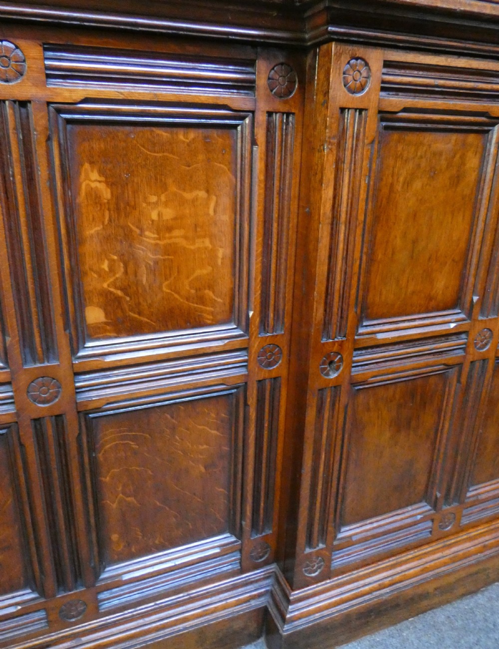 A large three-section antique oak bookcase featuring glazed upper doors above panelled lower cupboards. View VIII