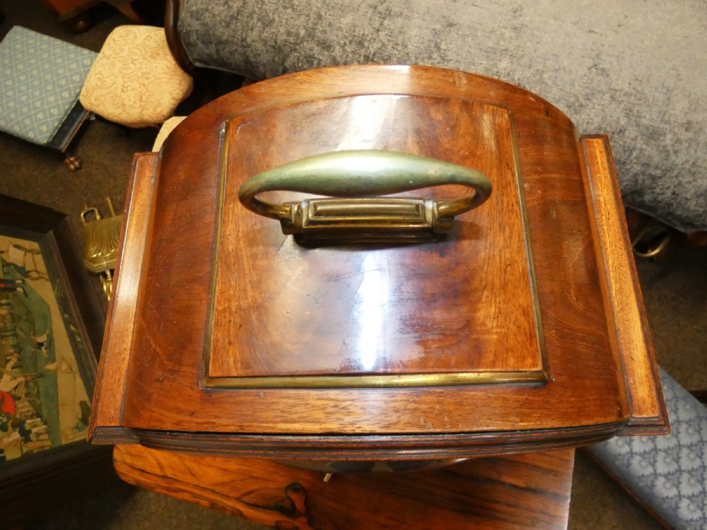 An antique dark mahogany bracket clock featuring an arched top with a brass carrying handle, a circular white dial signed Thos. Howard London, and brass fish-scale grilles. View X