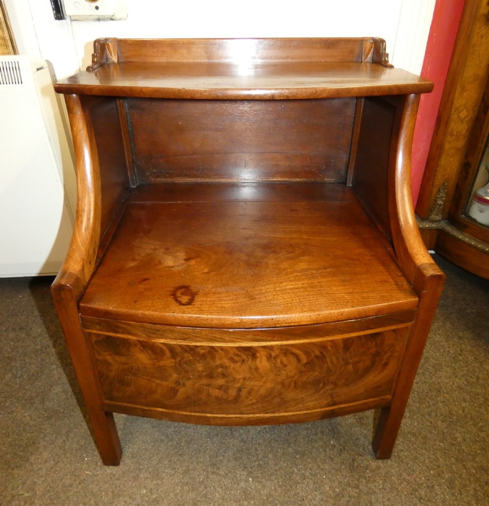 An antique Georgian mahogany bedside commode featuring an open upper shelf section with curved sides and a veneered lower cabinet. View II