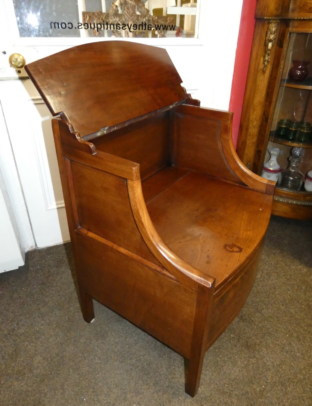 An antique Georgian mahogany bedside commode featuring an open upper shelf section with curved sides and a veneered lower cabinet. View V