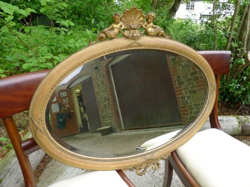 A Good Late 19th/early 20th Century, Oval Gilded Mirror with Mythical Fish Tailed Cherubs and Swags